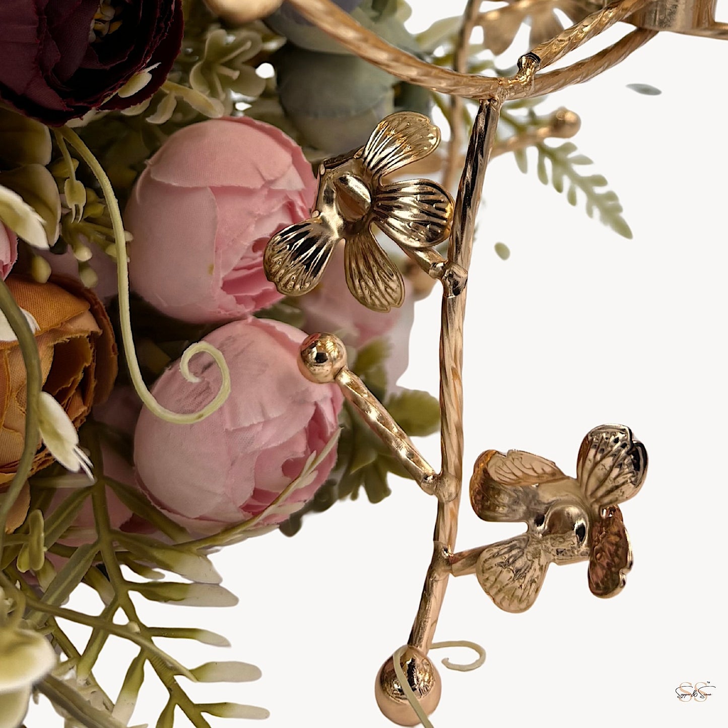 Close-up of an amber glass centerpiece bowl with gold floral metal legs showcasing detailed flower accents, perfect for luxury table styling by Supper & Scene.