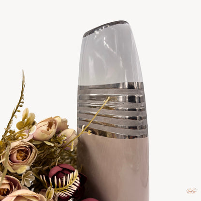 Close-up of a modern grey and white ceramic vase with metallic silver stripe detailing and a sleek curved silhouette, by Supper and Scene.
