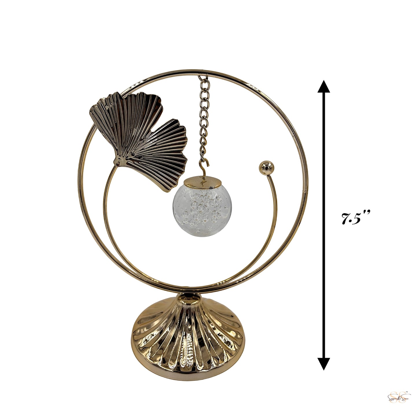 Gold decorative showpiece featuring a textured leaf accent and hanging crystal-like orb, styled with artificial flowers for modern interiors, by Supper & Scene.