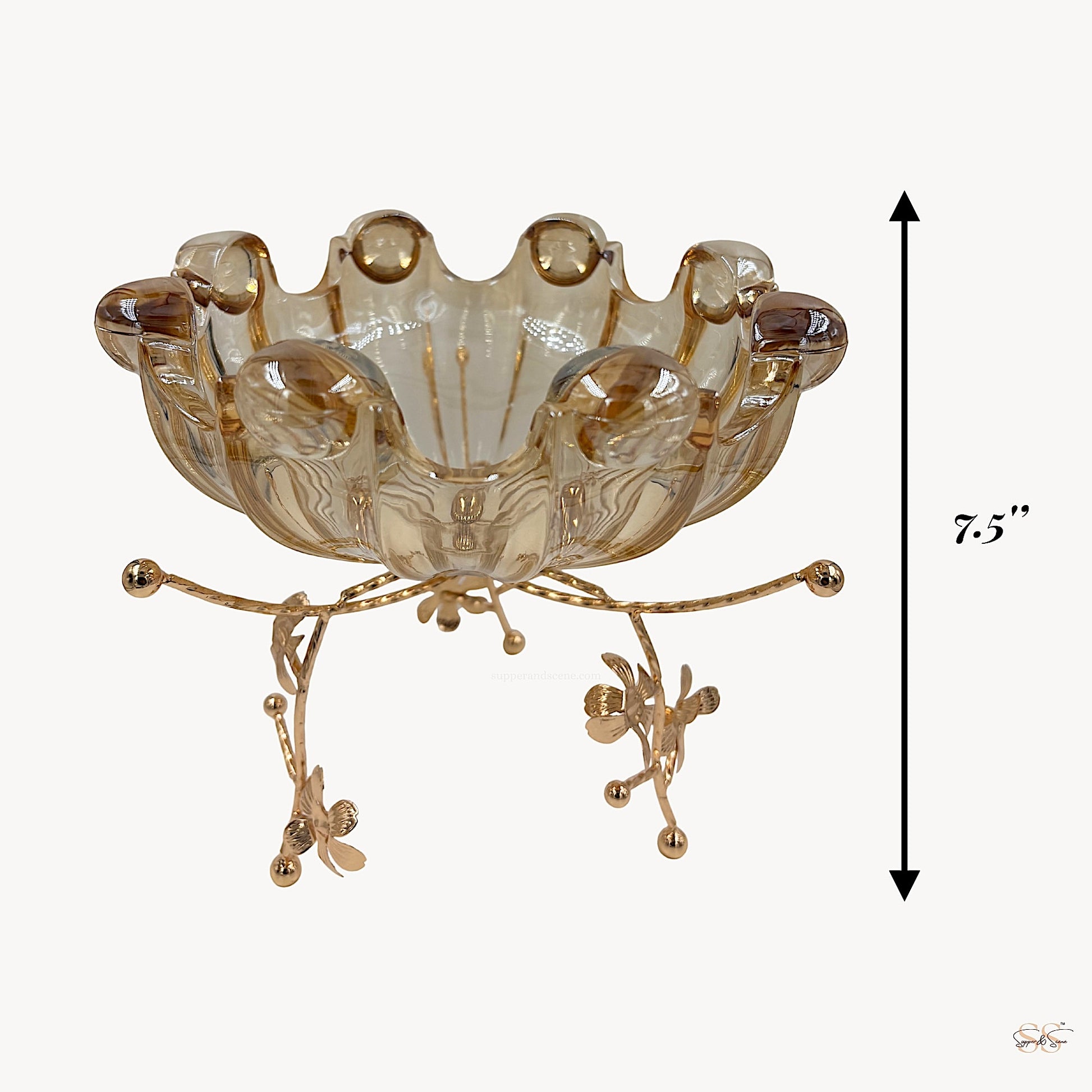 Amber-toned decorative glass centerpiece bowl elevated on an ornate gold floral metal stand, measuring 7.5 inches in height by Supper & Scene.