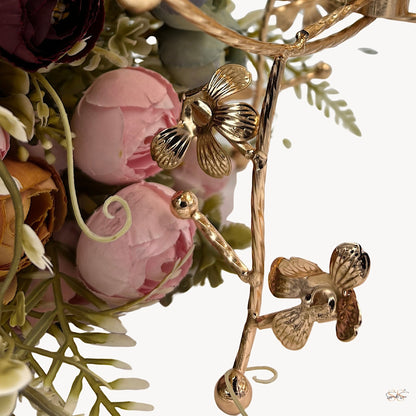 Close-up of an amber glass centerpiece bowl with gold floral metal legs showcasing detailed flower accents, perfect for luxury table styling by Supper & Scene.