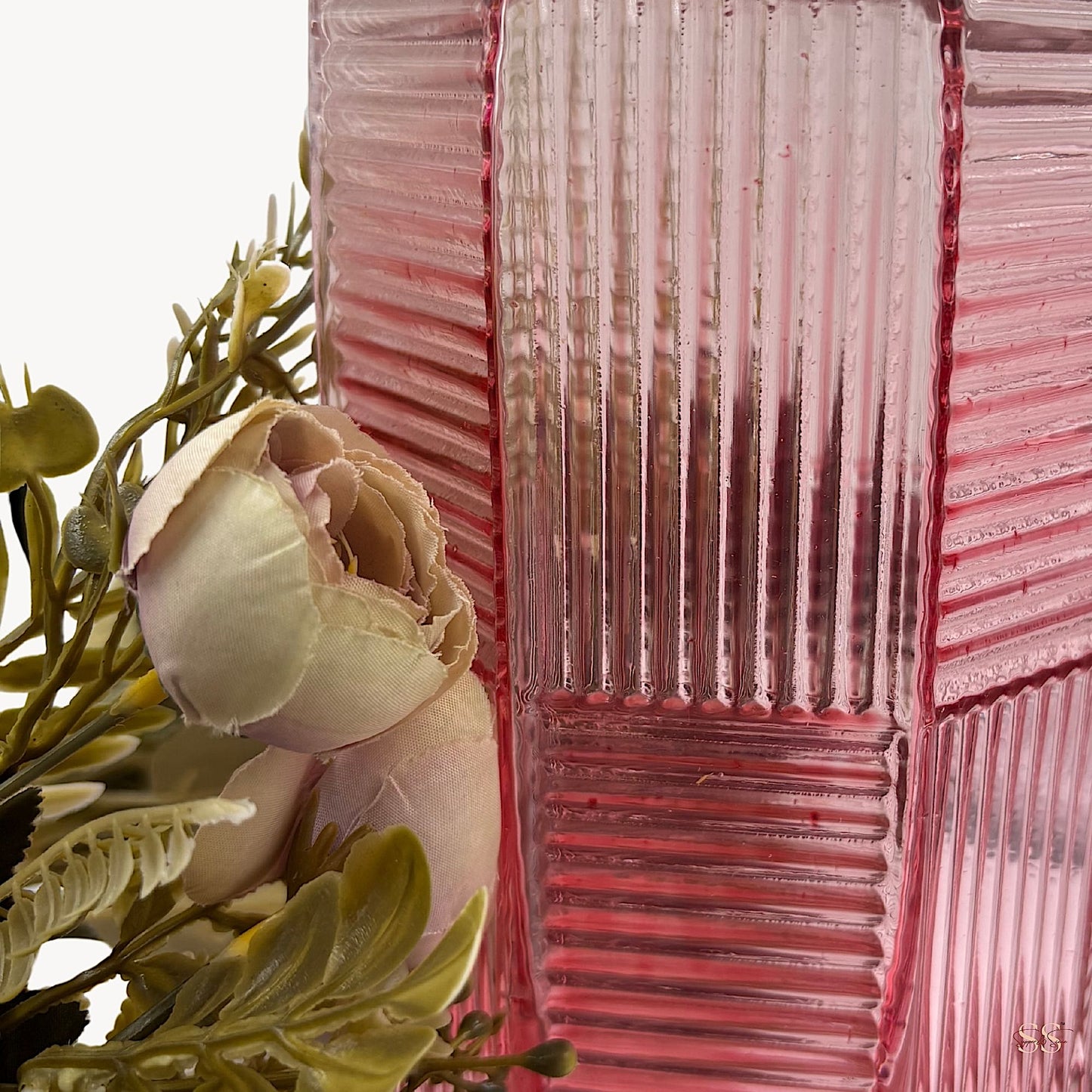 Close-up image of a pink ribbed glass vase with a gold-plated geometric neck, showcasing its textured design alongside pastel artificial flowers by Supper & Scene.