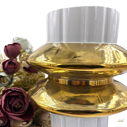 Close-up of a white and gold decorative glass vase featuring a ribbed white top and wide glossy gold center, styled with artificial flowers by Supper & Scene