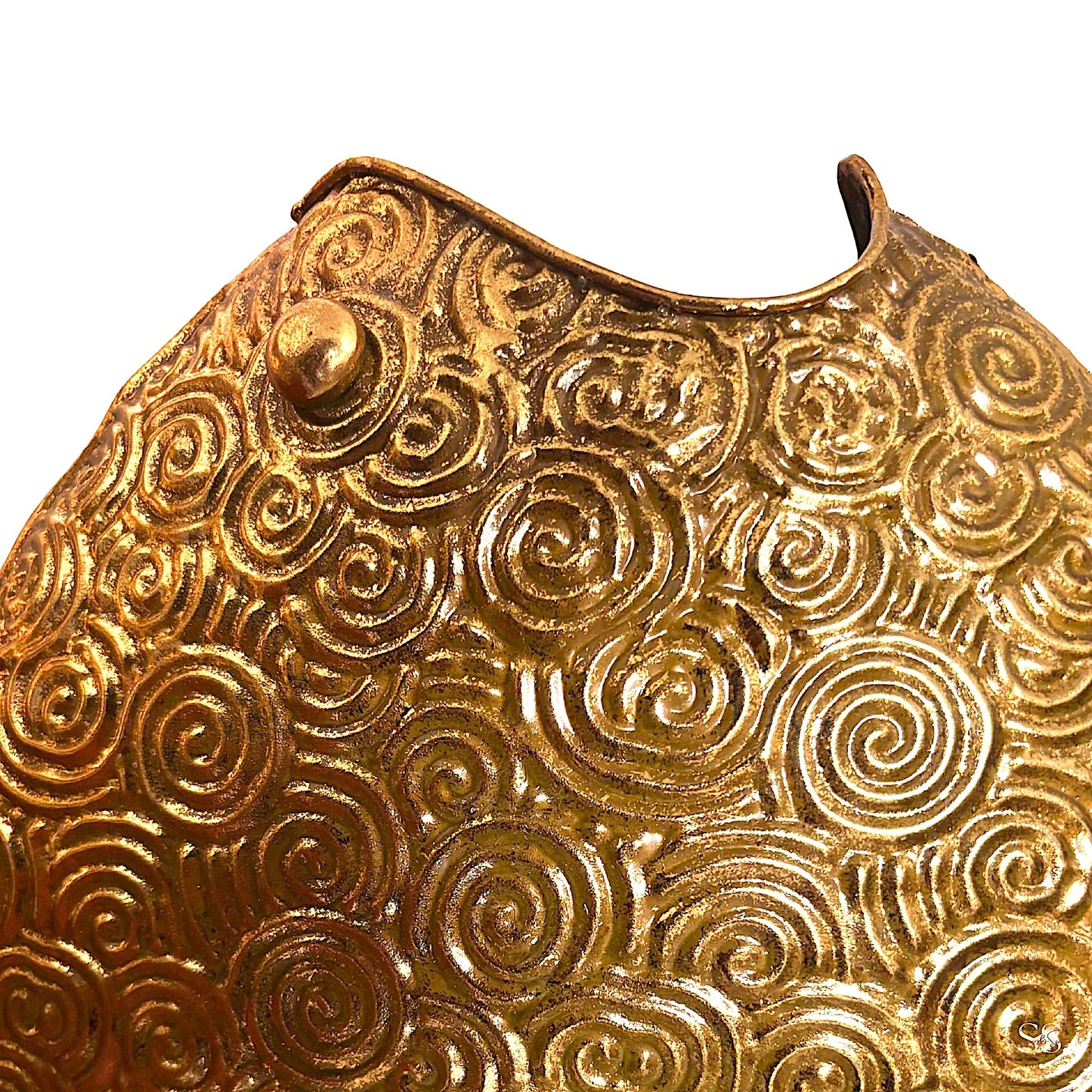 Vintage-inspired gold metal showpiece with raised circular swirls displayed on a tabletop by Supper & Scene.