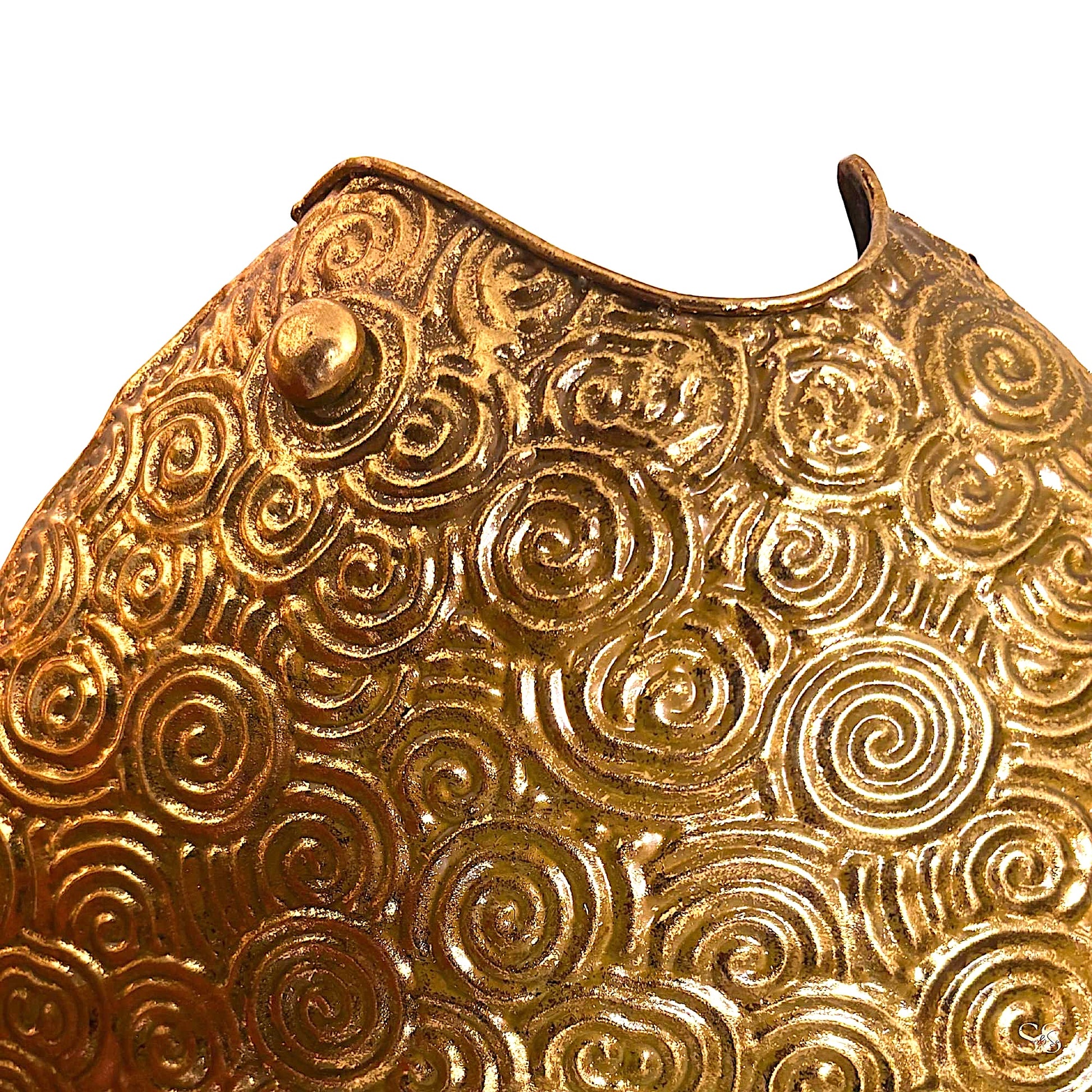 Vintage-inspired gold metal showpiece with raised circular swirls displayed on a tabletop by Supper & Scene.