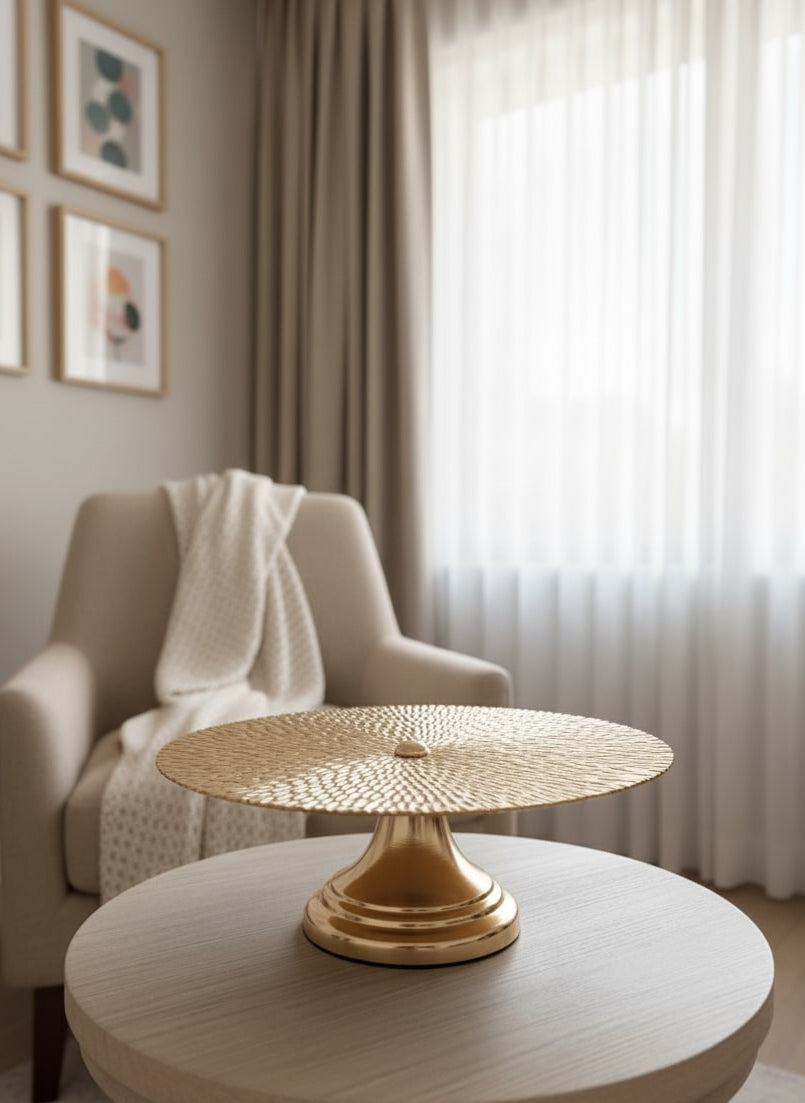 Round wooden table with a gold base in a room with a beige armchair  on the wall by supper and scene