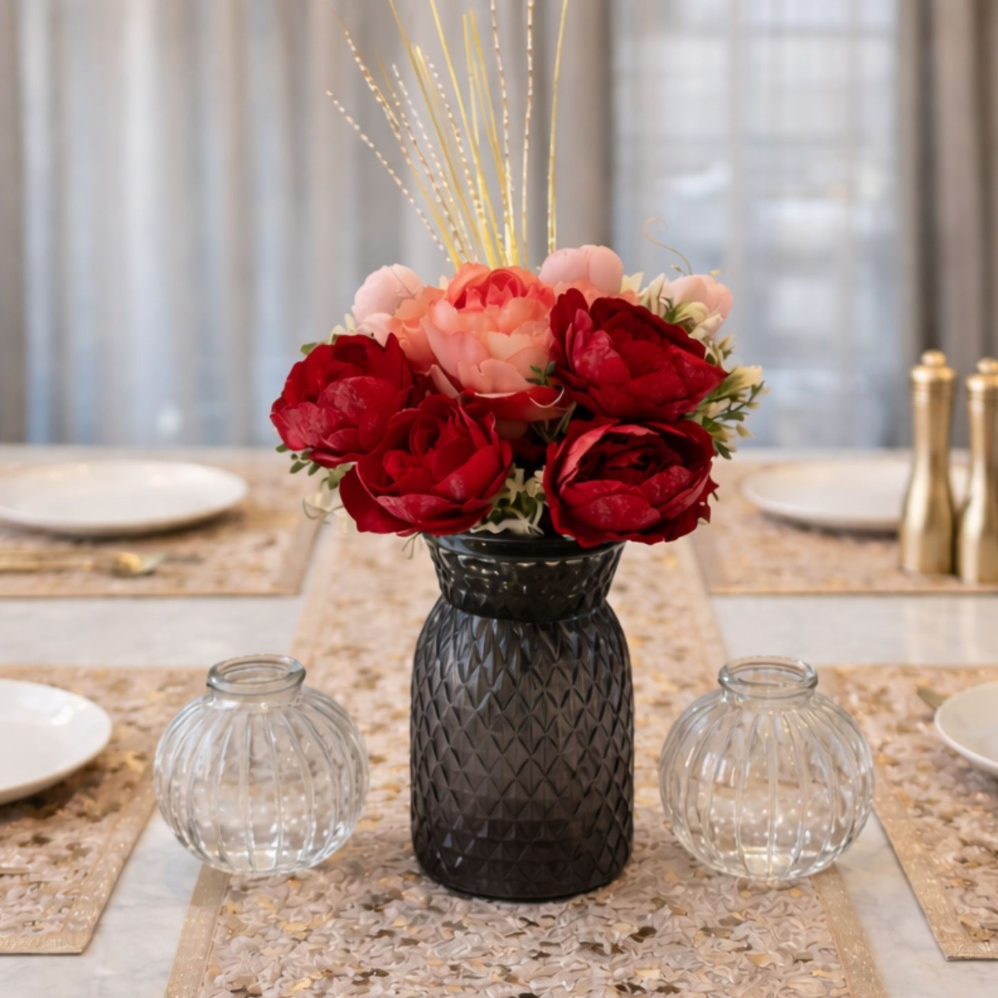 Floral arrangement in a black vase on a table with decorative elements