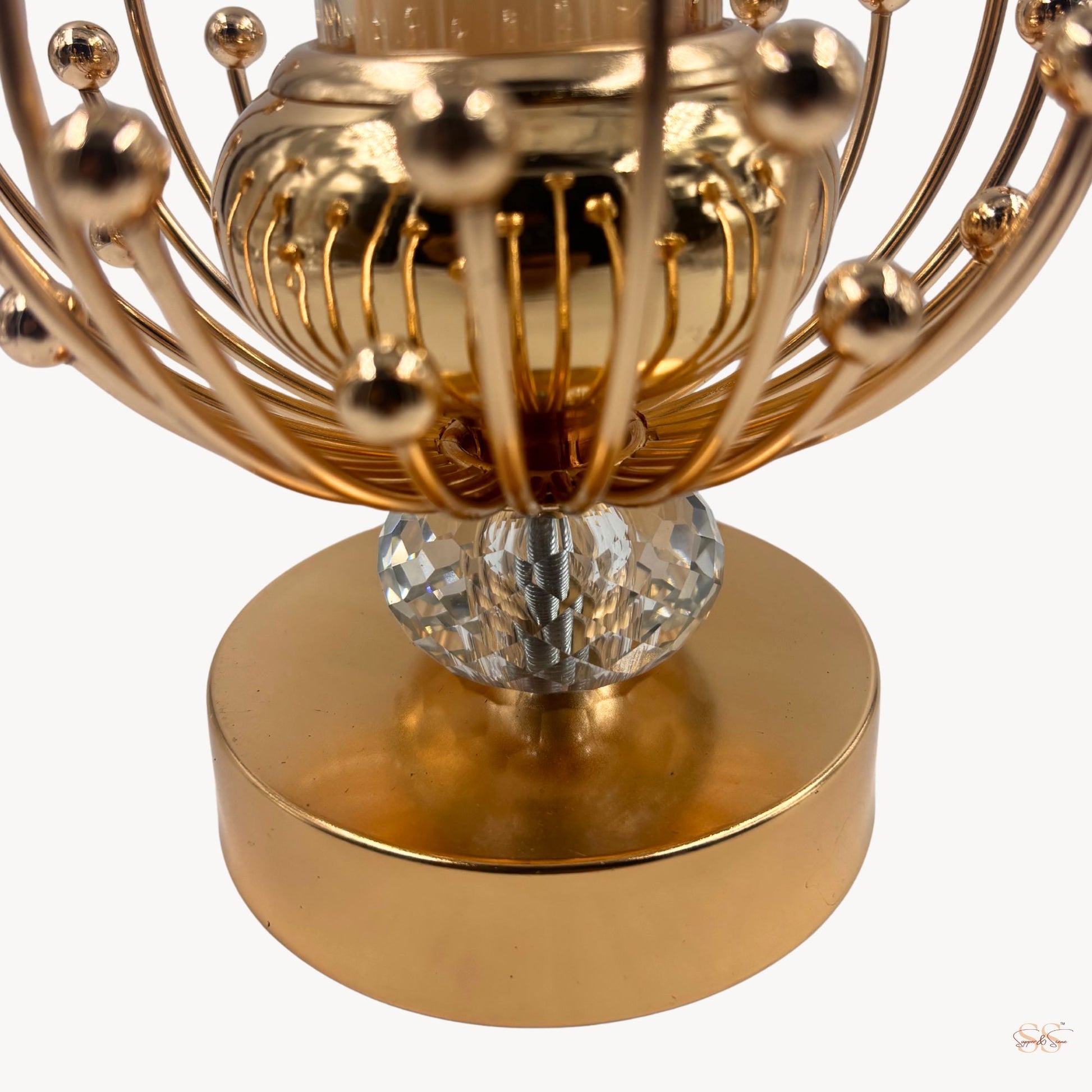Gold decorative object with crystal base on a white background