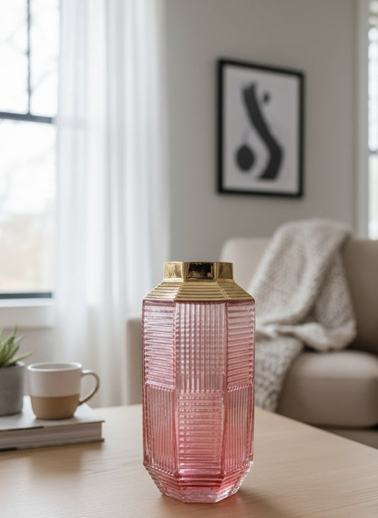Pink textured vase with gold accents on a wooden table in a living room setting by supper and scene