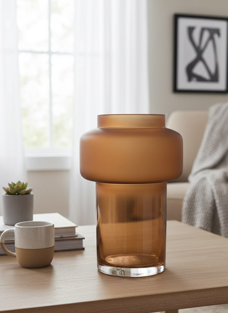 Brown glass vase on a wooden table in a living room setting