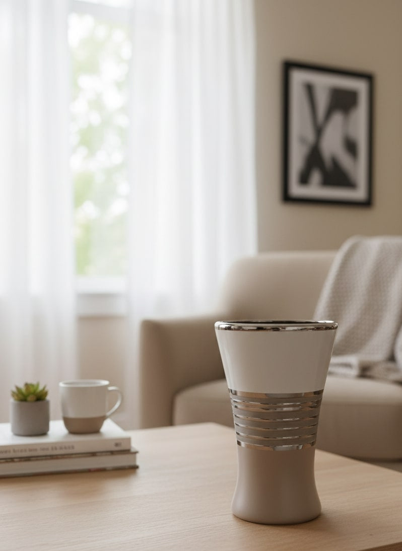 White vase on a wooden table with a blurred living room background
