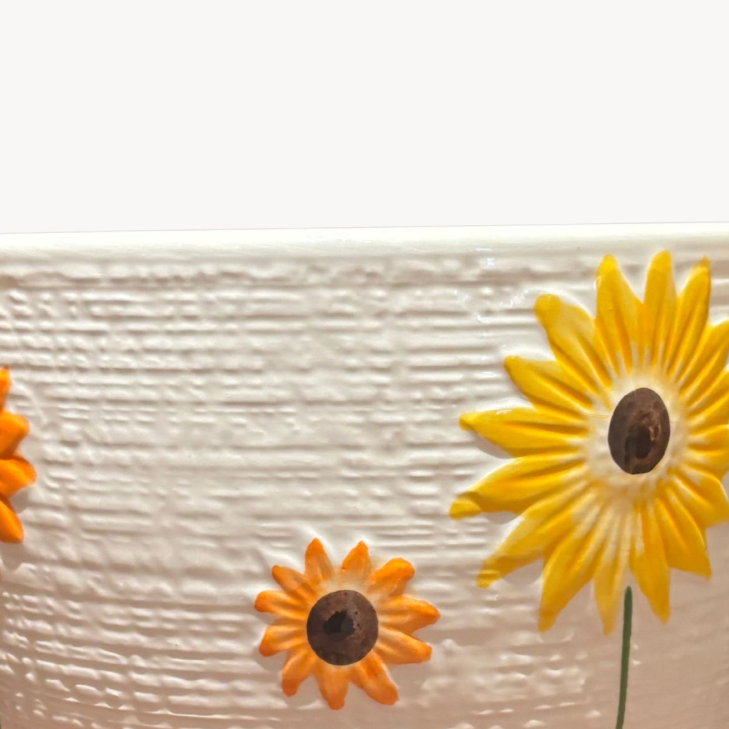 Close up of sunflower design on textured ceramic planter decorative indoor flower pot for succulents