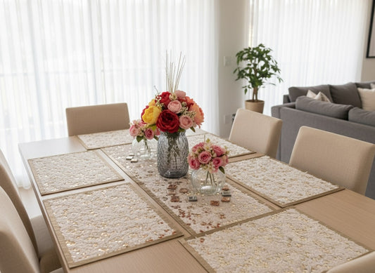 Dining room with a table set for six, featuring placemats and floral centerpieces by supper and scene